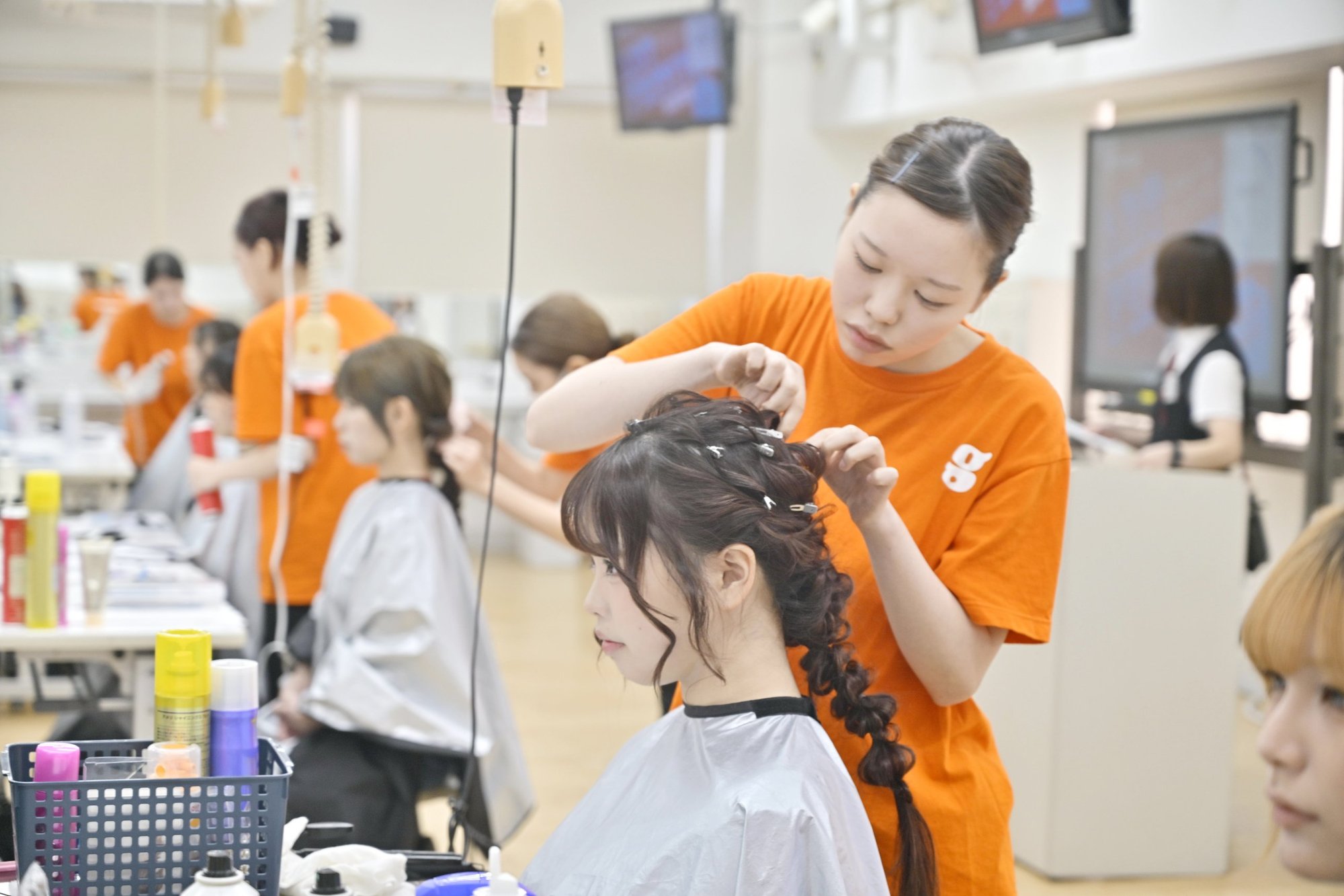 モデルに編みおろしを施術する学生